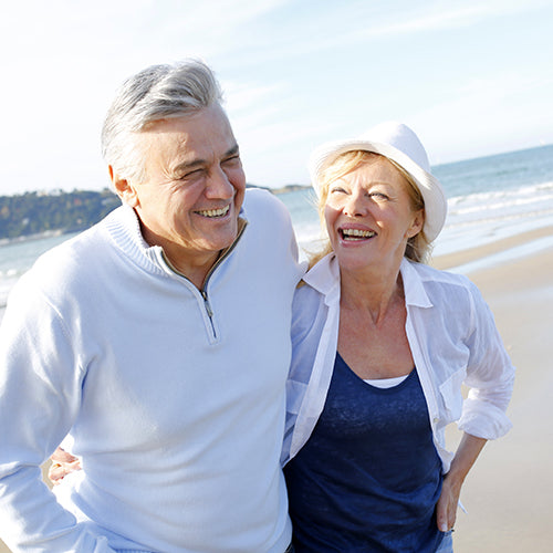 Senior couple walking on beach - healthy aging with anti-inflammatory curcumin